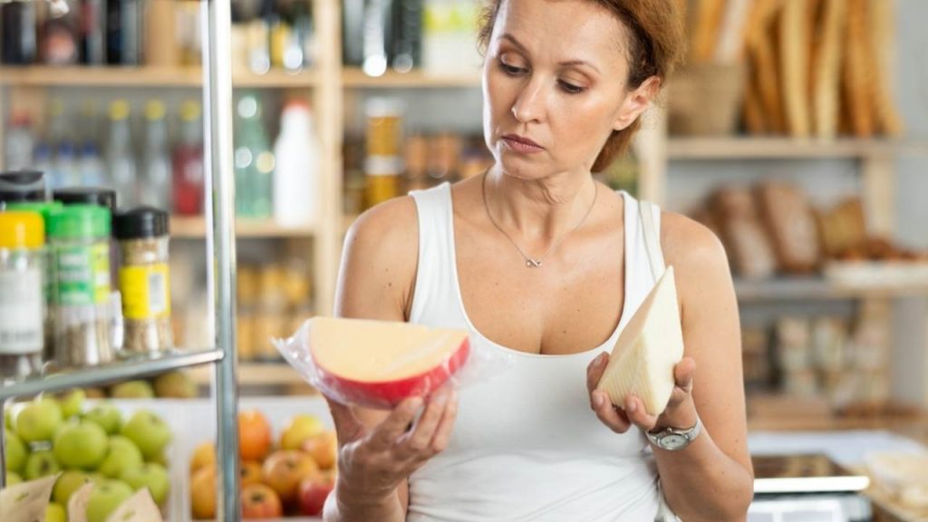 Žena si v potravinárskom oddelení supermarketu starostlivo vyberá lahodný syr