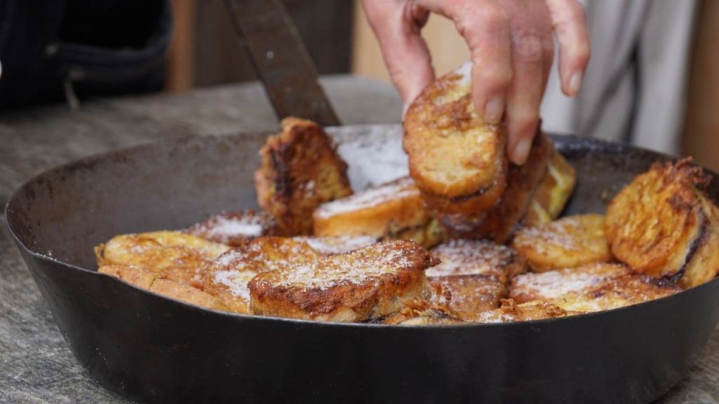 Tradičný rakúsky dezert „Pofesen“ (francúzsky toast s cukrom a slivkovým džemom) podávaný v železnej panvici v horskej chate