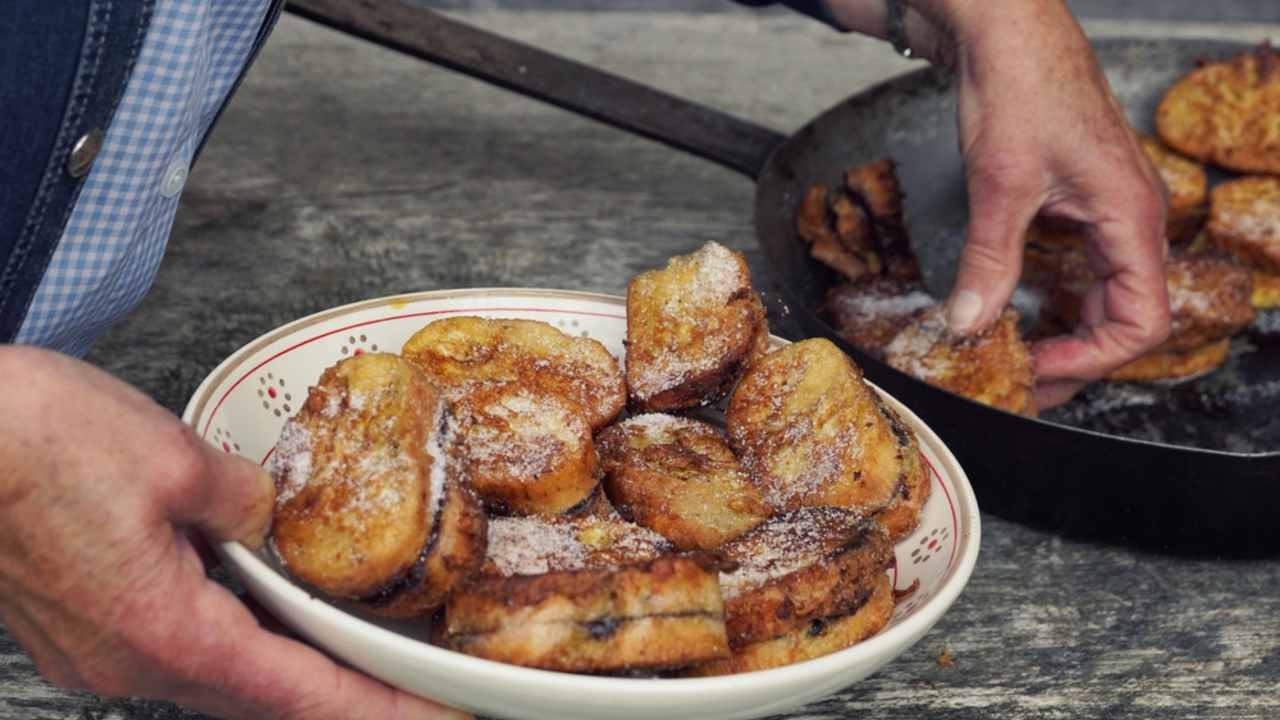 Tradičný rakúsky dezert „Pofesen“ (francúzsky toast s cukrom a slivkovým džemom) podávaný v železnej panvici v horskej chate