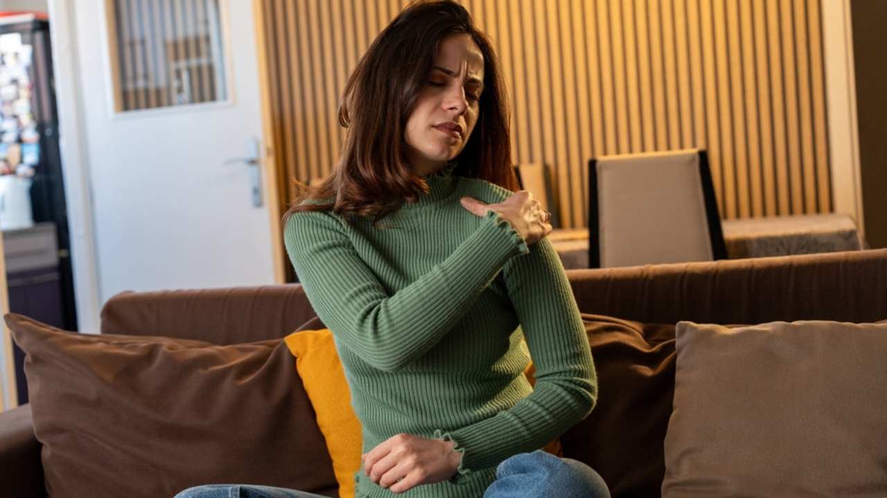 Žena trpiaca bolesťami ramien a krku doma. Bolesti svalov spôsobené myofasciálnym bolestivým syndrómom a fibromyalgiou, reumatizmom, bolesťami lopatky a krčnej chrbtice. Ergonomický prístup